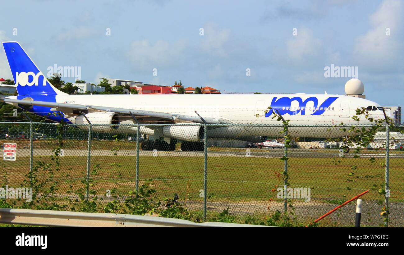 A Joon (defunct and now operated by Air France) Airbus A340-313 F-GLZP, taxiing on the runway prior to take off from SXM airport, St Maarten. Stock Photo