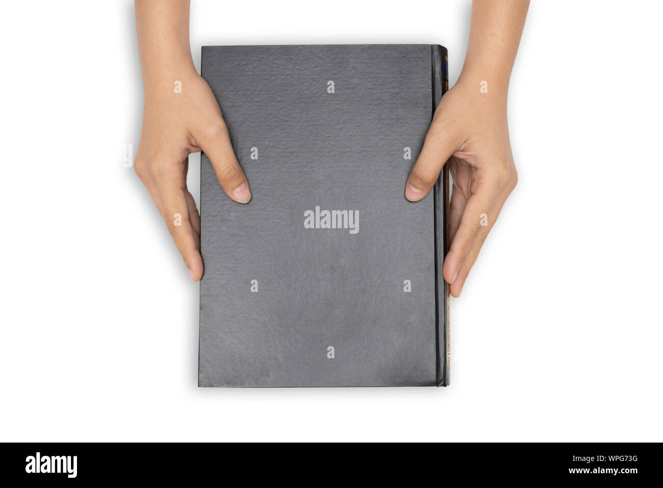 Hands holding closed book with black blank cover on white background. Stock Photo