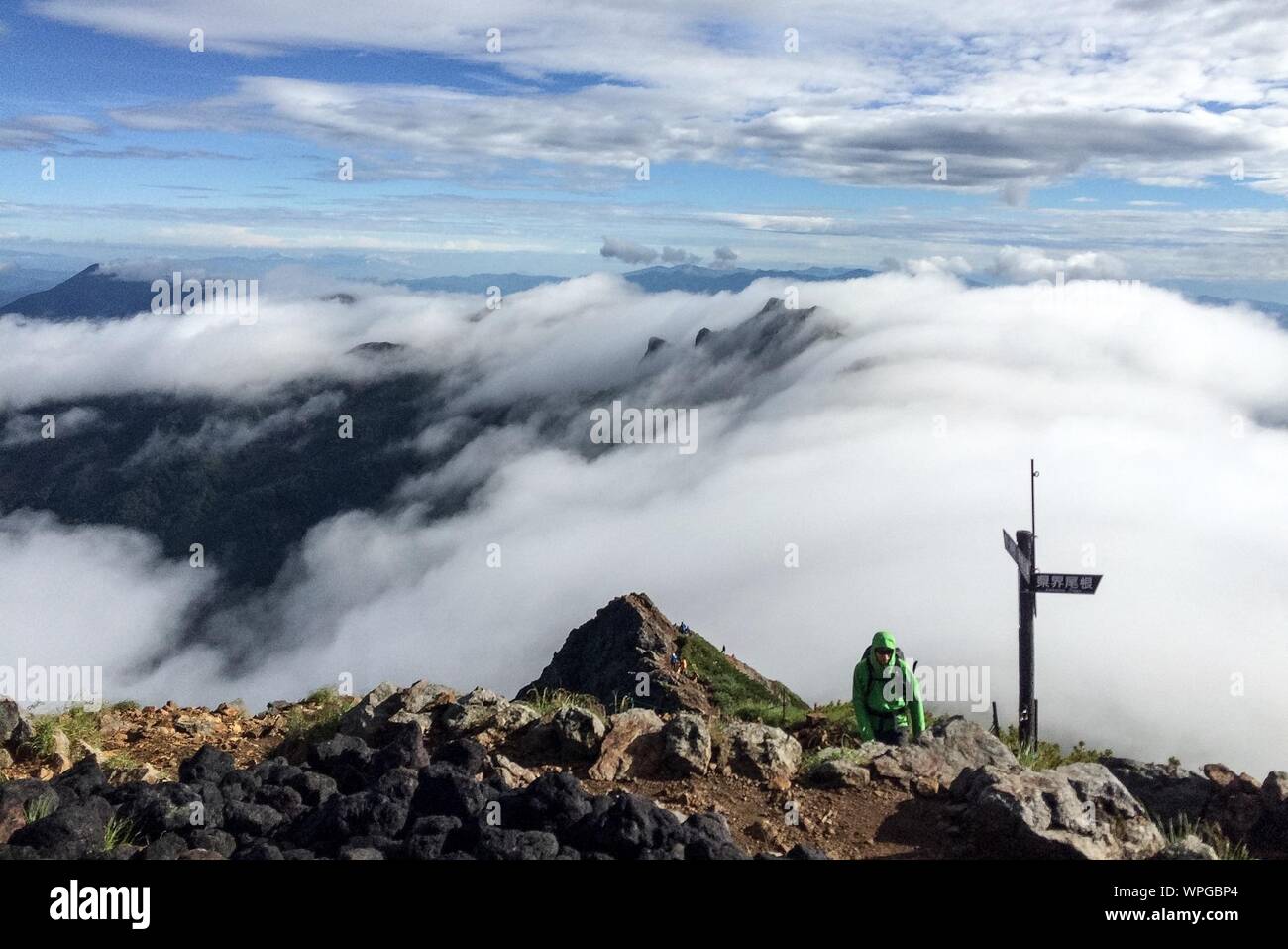 High Angle View Of Person Walking On Mount Aka Against Cloudy Sky Stock Photo