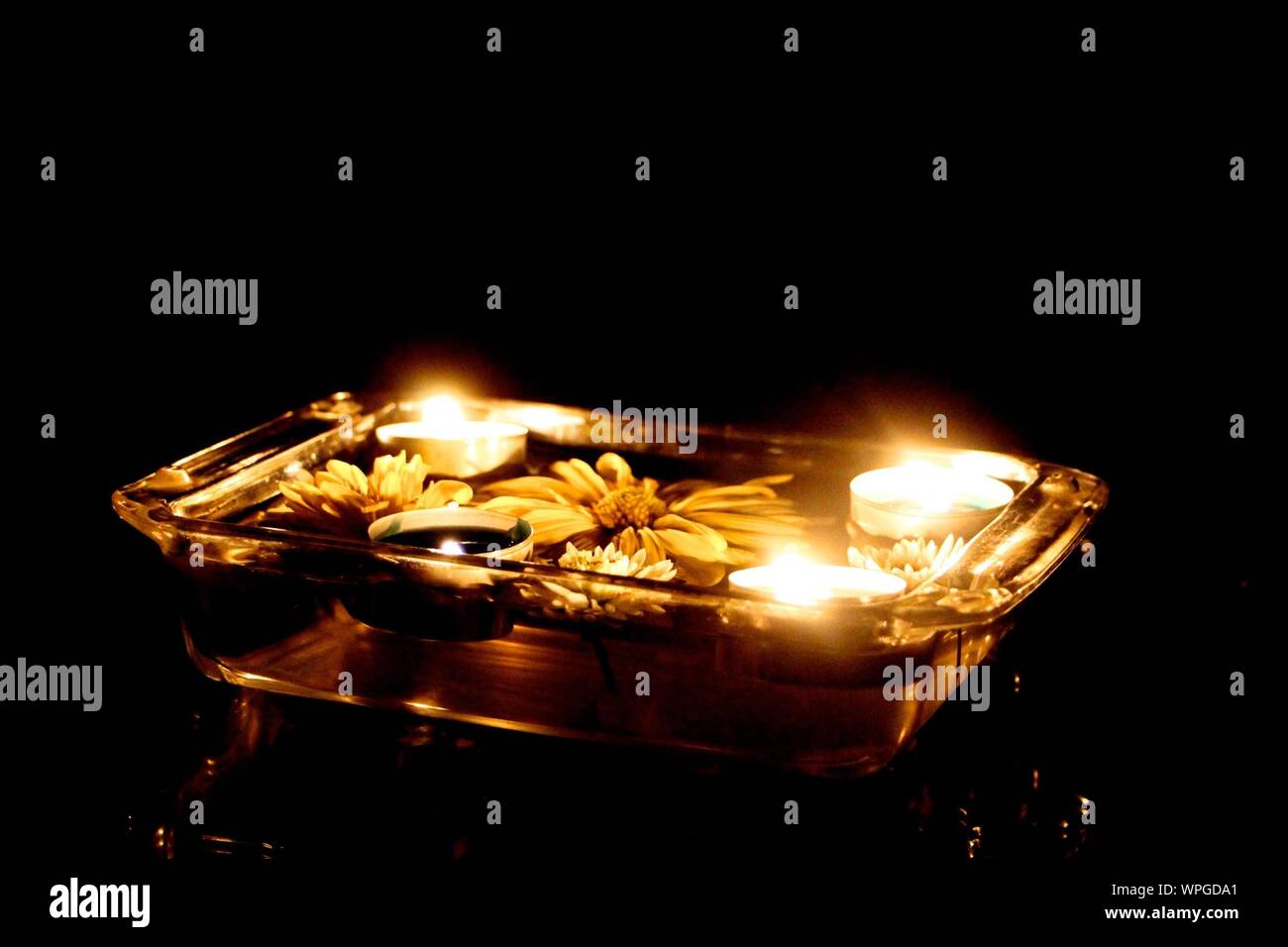 Tea Light Candles Floating On Water In Container Stock Photo Alamy