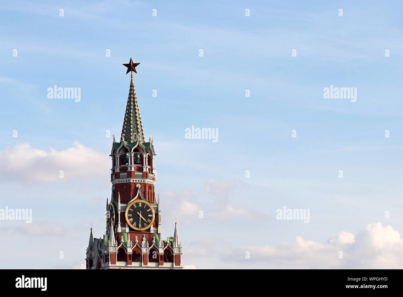 Chimes of Spasskaya tower, symbol of Russia on Red Square. Red star on Moscow Kremlin tower against blue sky with clouds Stock Photo