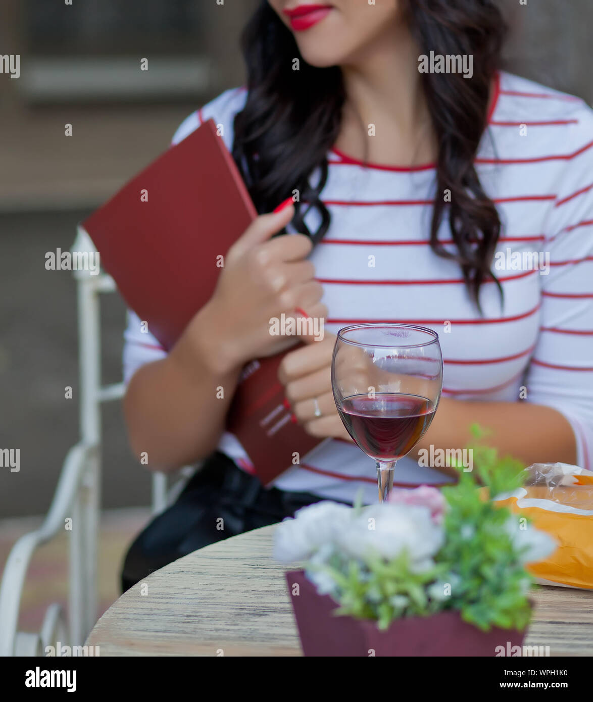 Pretty brunette woman in a striped t-shirt holding a magazine and ...