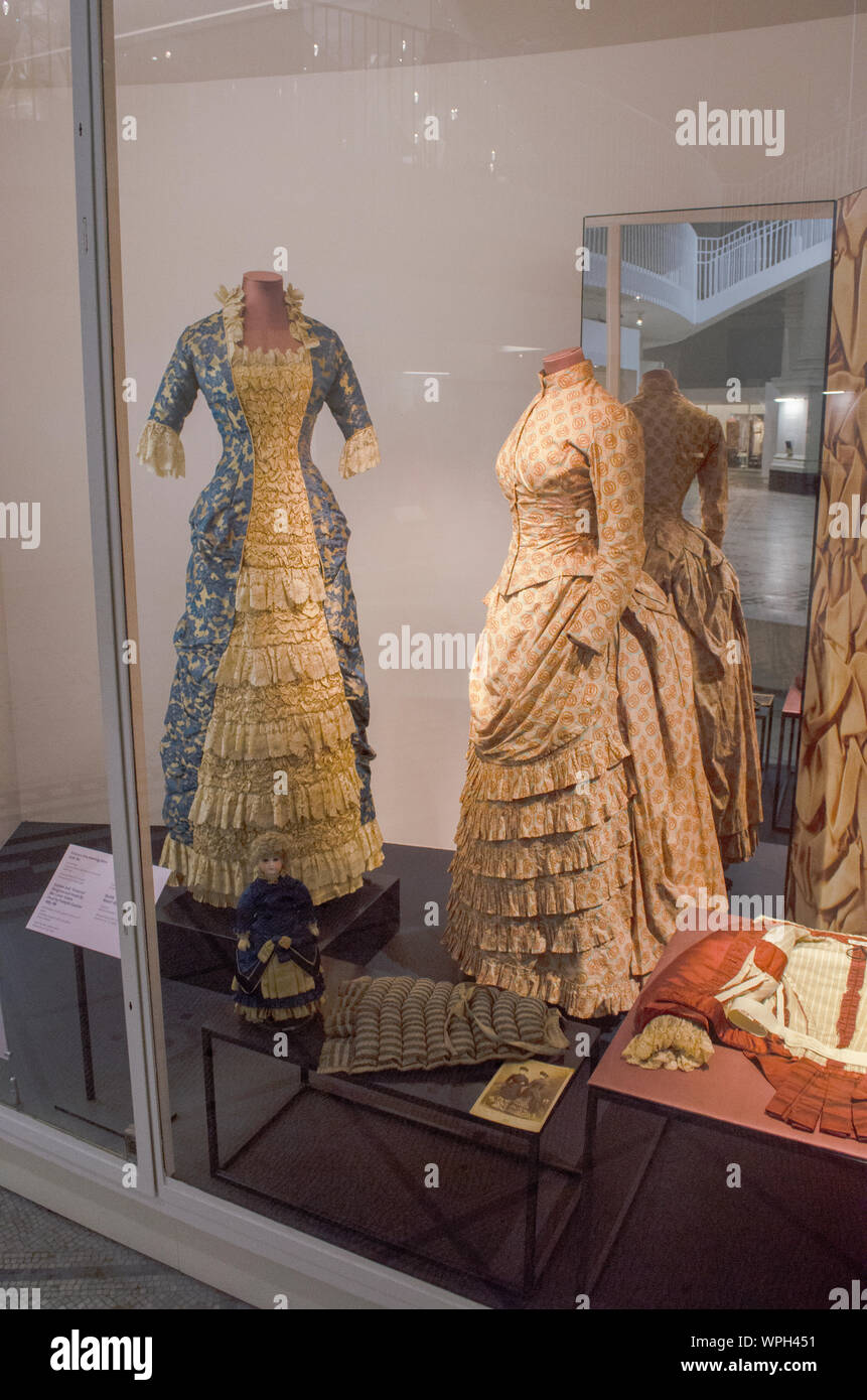 Right: Basqued bodice dress | 1885 | Great Britain | Printed cotton ||| Left: Princess dress of blue and gold Jacquard-woven silk | 1878-1880 | GB Stock Photo