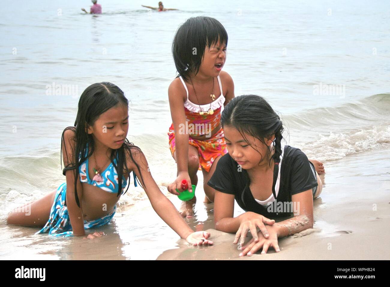 Girls Playing On Shore At Beach Stock Photo