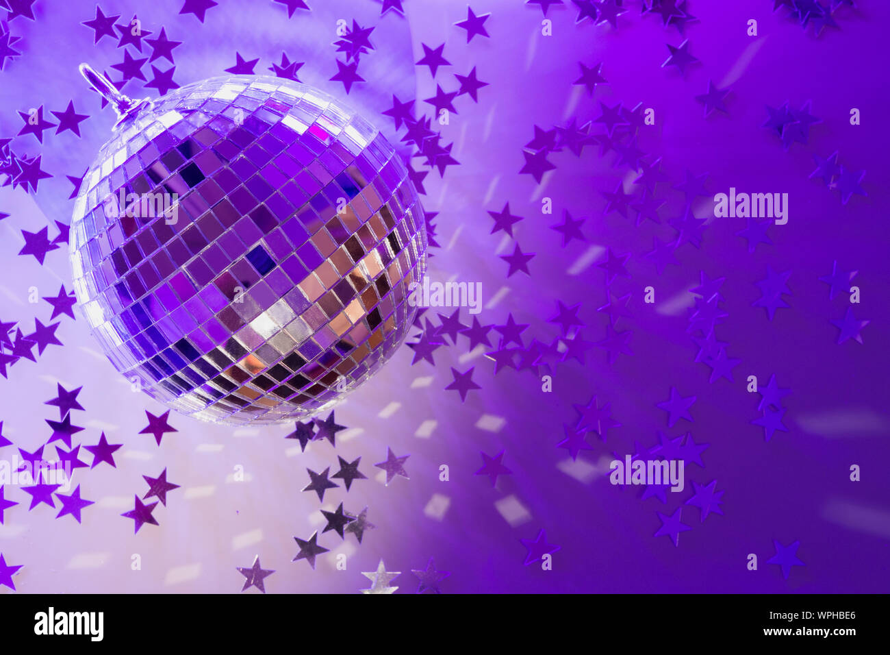 Christmas disco ball with rays on neon blue. Creative Xmas party