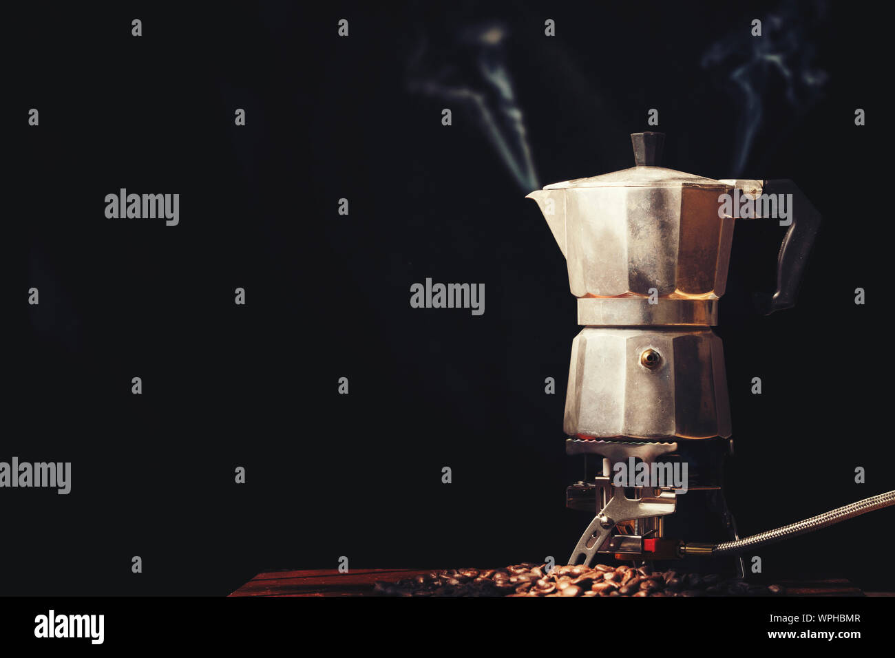 Moka pot old coffee maker and coffee beans on black background Stock Photo