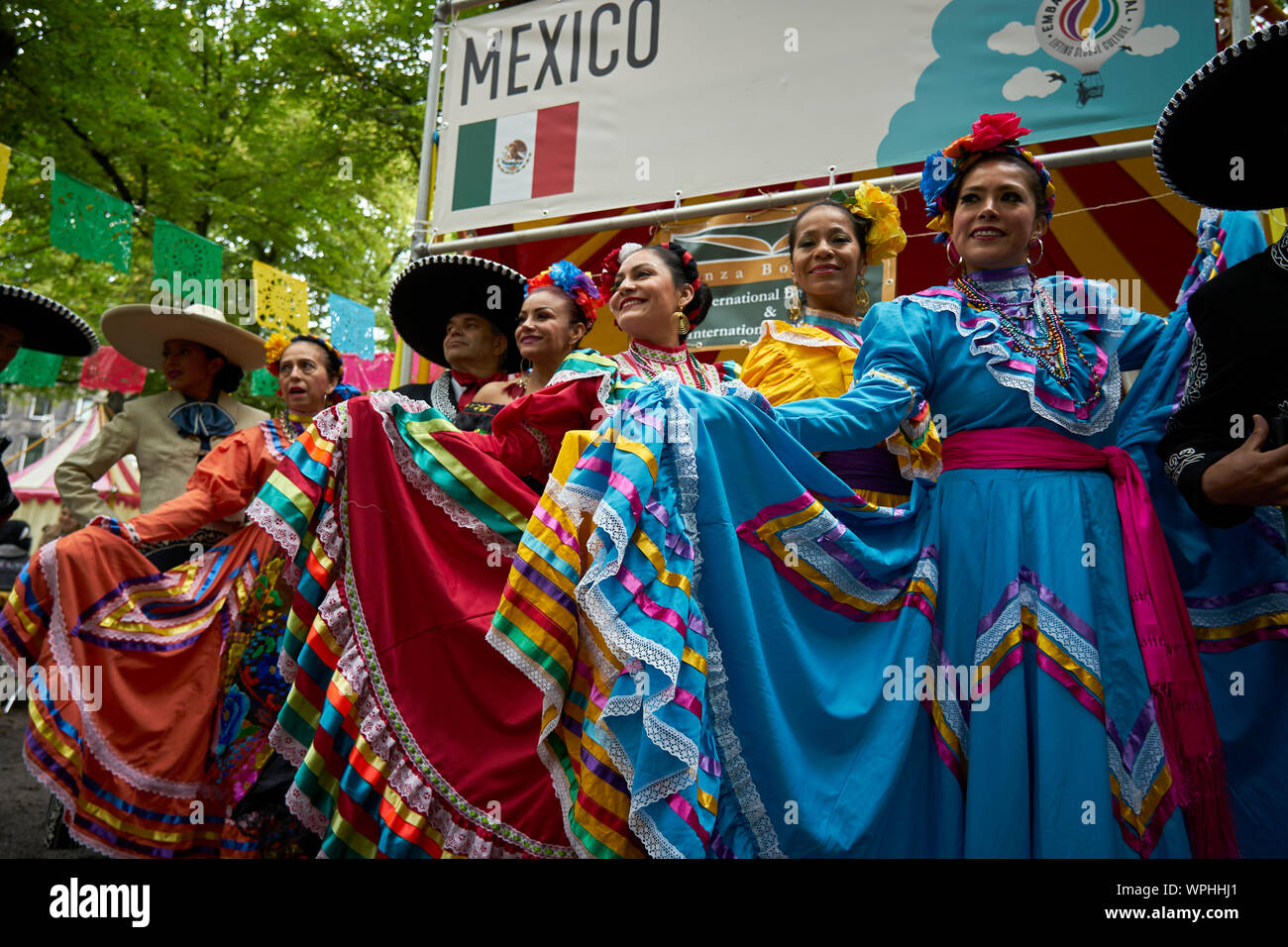 A group of Mexicans pose in the typical costume in front of the Mexican stand. Stock Photo