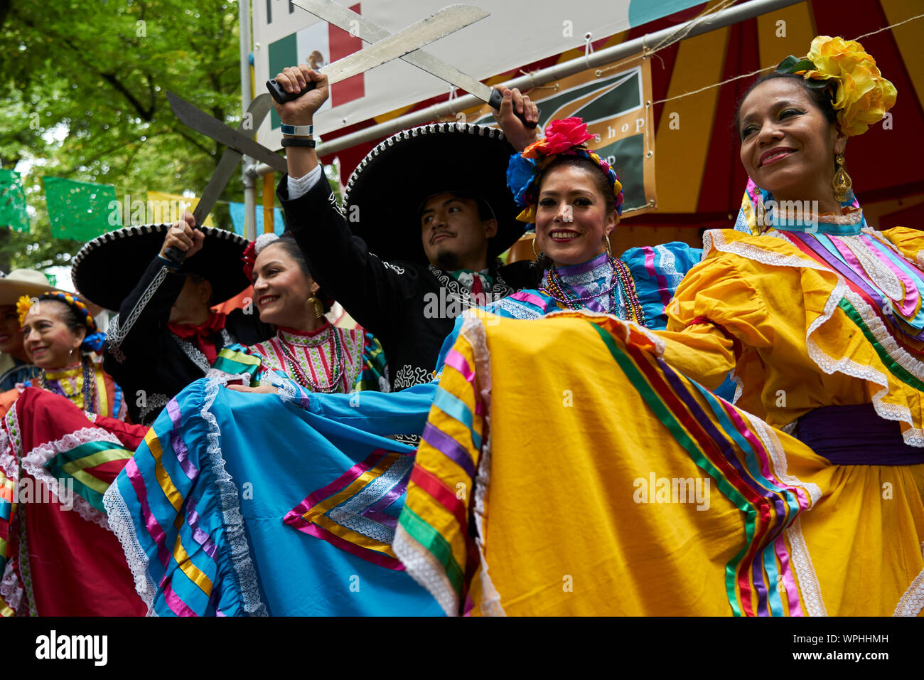 A group of Mexicans pose in the typical costume in front of the Mexican stand. Stock Photo