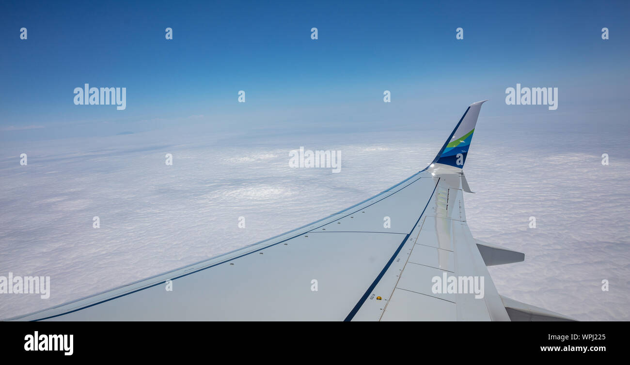 Los Angeles to Newark flight, USA. June 2, 2019. Alaska airlines plane wing over cloudscape, blue sky. Looking out of an airplane window. Stock Photo