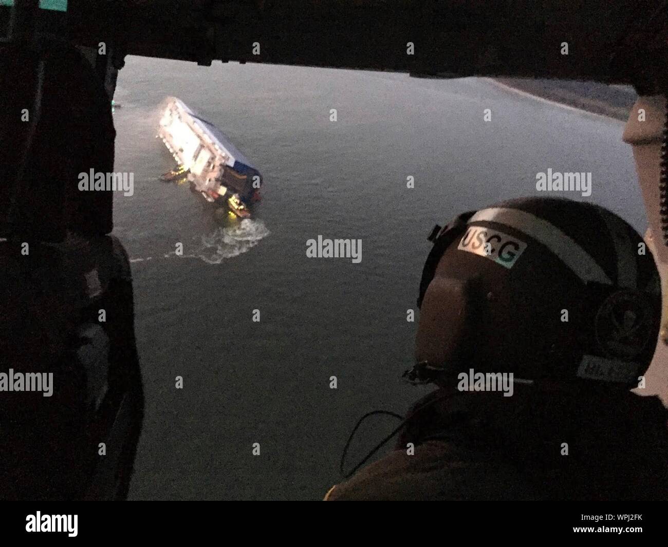St Simons Island, Georgia, USA. 08 September, 2019. Aerial view from a U.S. Coast Guard rescue helicopter showing the M/V Golden Ray cargo ship as it rests inverted in the water after suffering a fire and capsizing in St Simons Sound Aerial September 8, 2019 off St Simons, Georgia, USA. The 656-foot-long vehicle carrier, listing heavily after suffering a fire with 24 crew members aboard.  Credit: U.S Coast Guard/Alamy Live News Stock Photo
