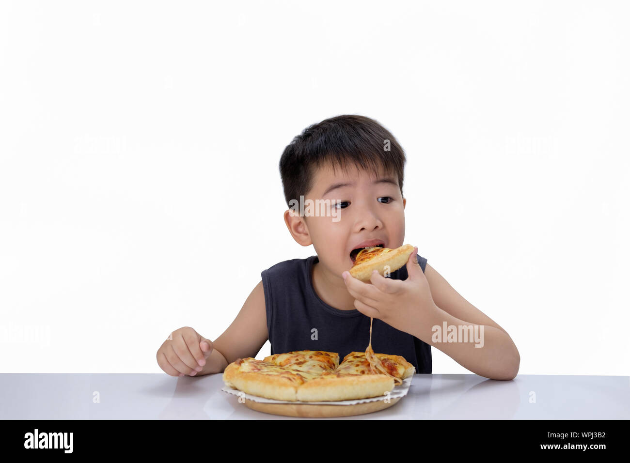 Asian boy  happy to eat pizza with a hot cheese is melting and stretching on a wooden pad.  Isolated on white background, choose focus point. Stock Photo