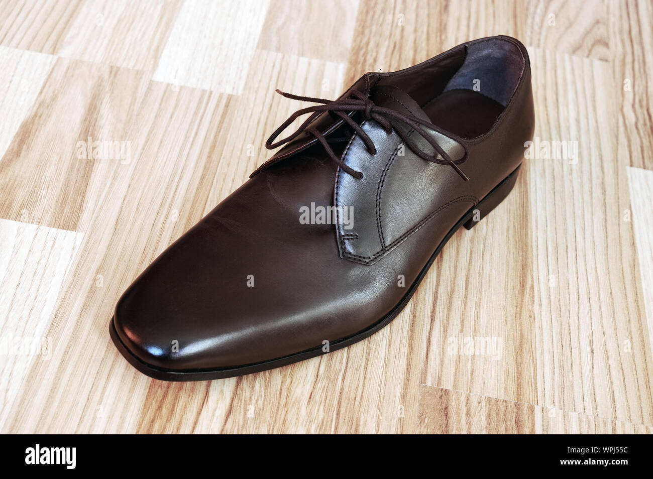 Close-up Of Leather Shoe On Hardwood Floor Stock Photo