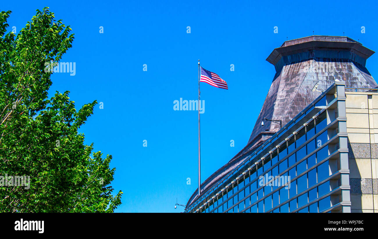 A view of the upper-rear portion of the United States' embassy in Ottawa, Canada., featuring an American flag. Stock Photo