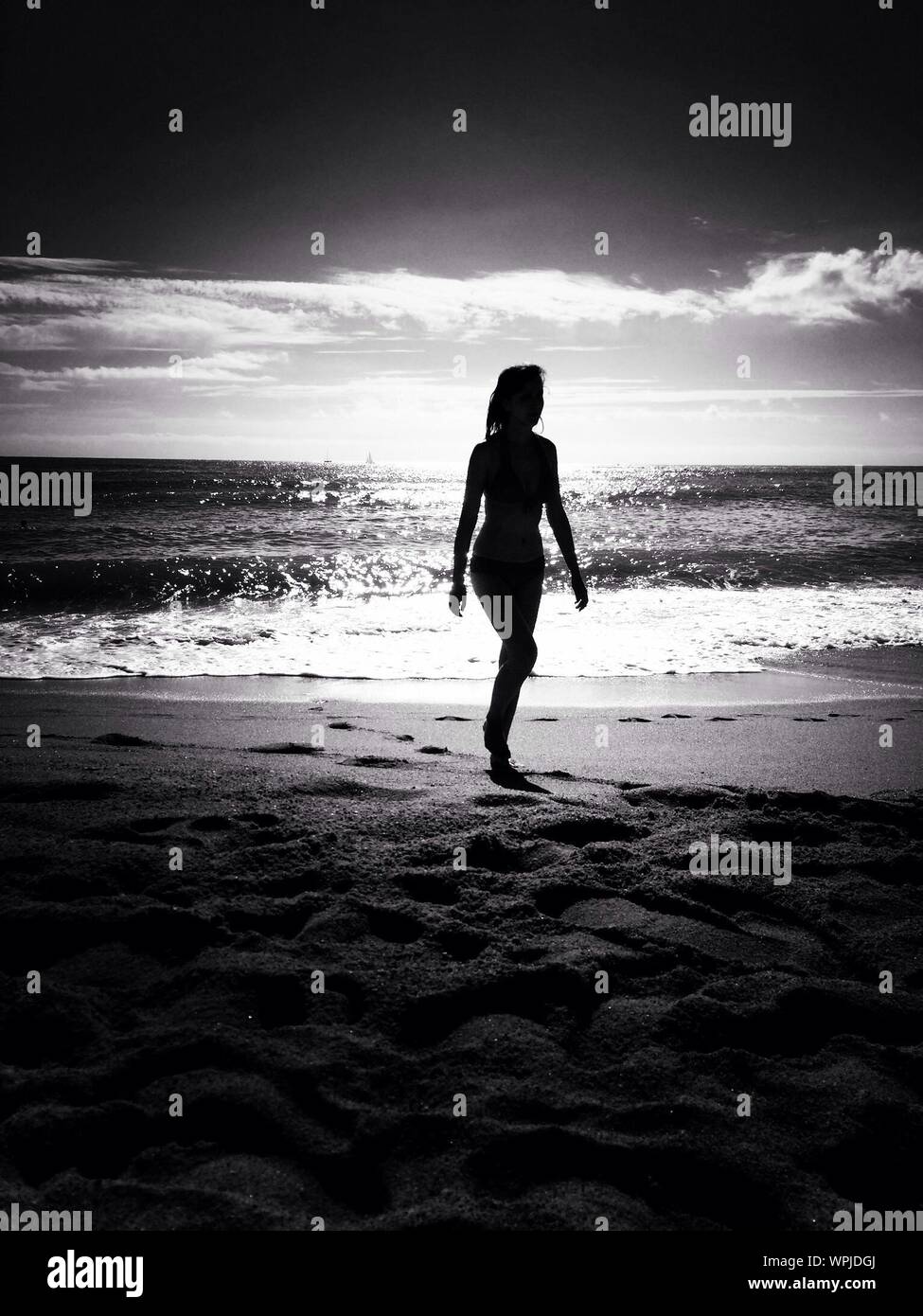 Silhouette of a woman walking on beach hi-res stock photography and ...