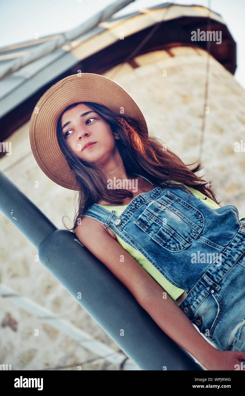 Tilt Shot Of Beautiful Young Woman In Hat Standing Against Building Stock  Photo - Alamy