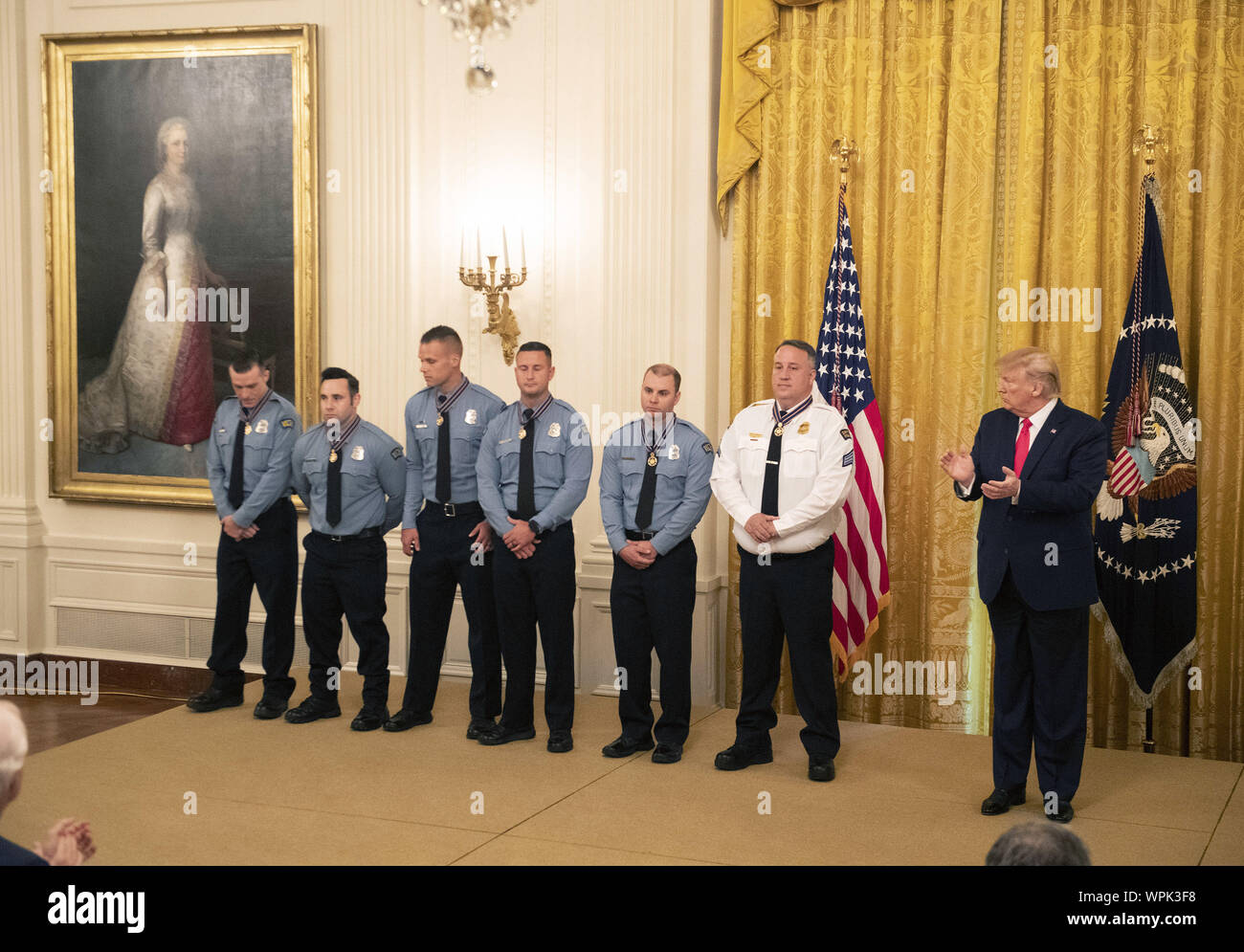 Washington, United States. 09th Sep, 2019. President Donald Trump applauds after awarding the Public Safety Officer Medal of Valor to Dayton Police Officers Sgt. William C. Knight, Officer Brian Rolfes, Officer Jeremy Campbell, Officer Vincent Carter, Officer Ryan Nabel, and Officer David Denlinger during a ceremony in the East Room at the White House in Washington, DC on Monday, September 9, 2019. Trump recognized the six Dayton officers who stoped a mass shooting on August 4th where nine people were killed and 27 more were injured. Credit: UPI/Alamy Live News Stock Photo