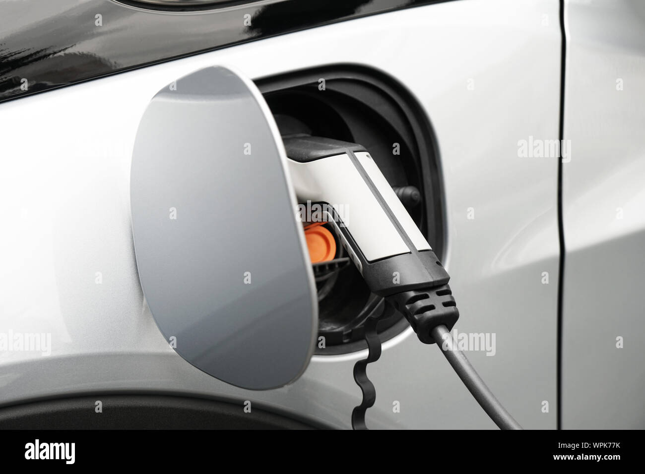 EV or Electric car at charging station plugged in with power supply