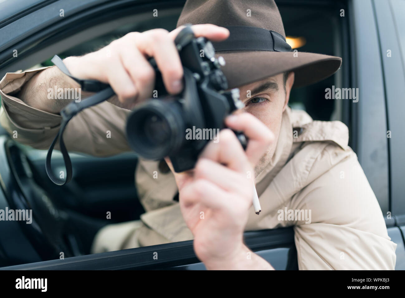 Spy or paparazzo photographer, man using camera in his car Stock Photo