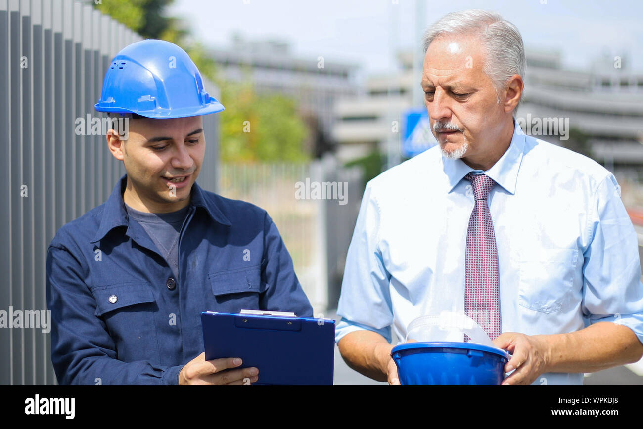 Two architect developers reviewing building plans at construction site Stock Photo