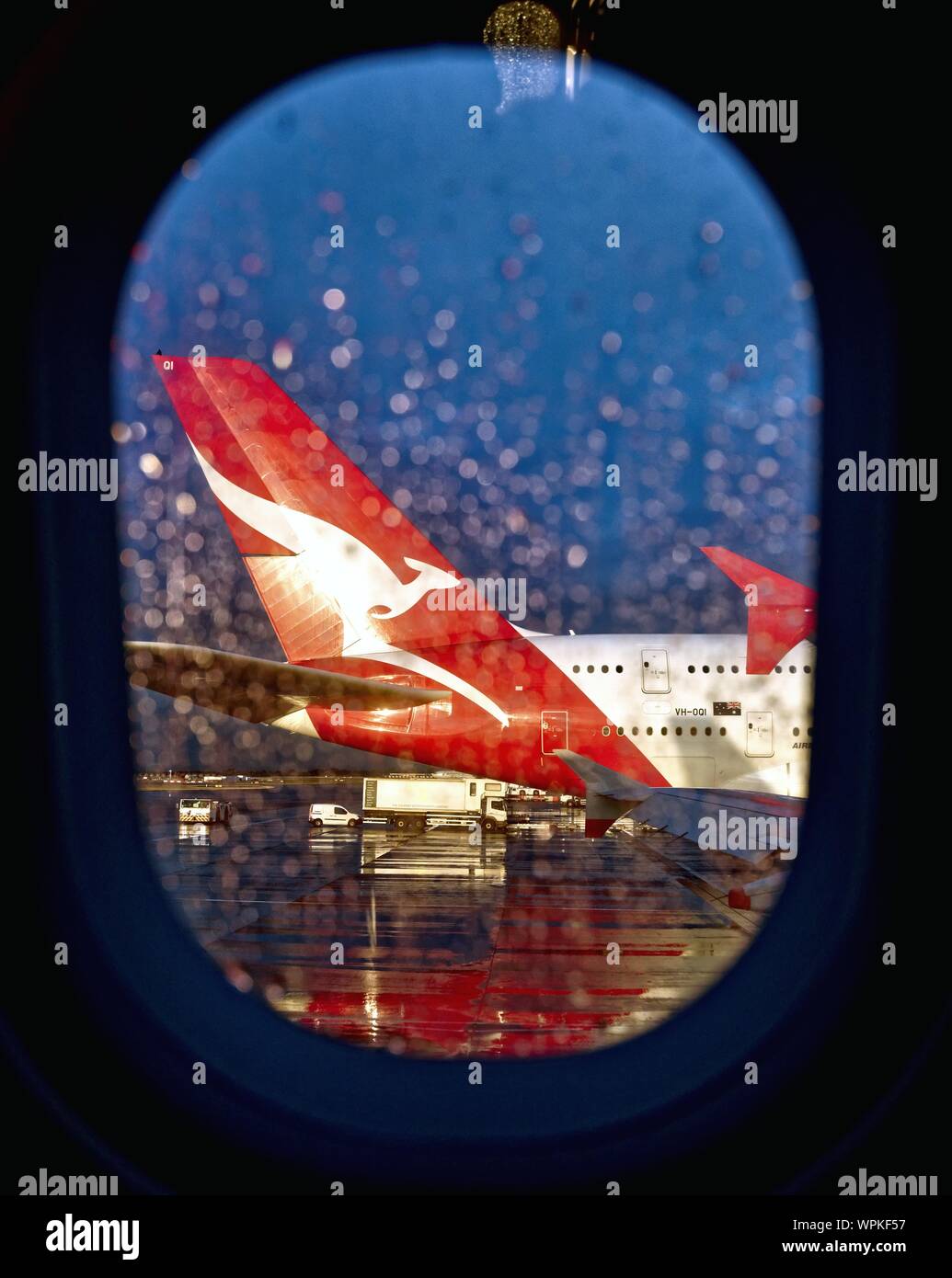The tail plane of the Qantas A380 super jumbo with the company logo kangaroo as seen through an adjacent passenger jet window Heathrow London UK Stock Photo