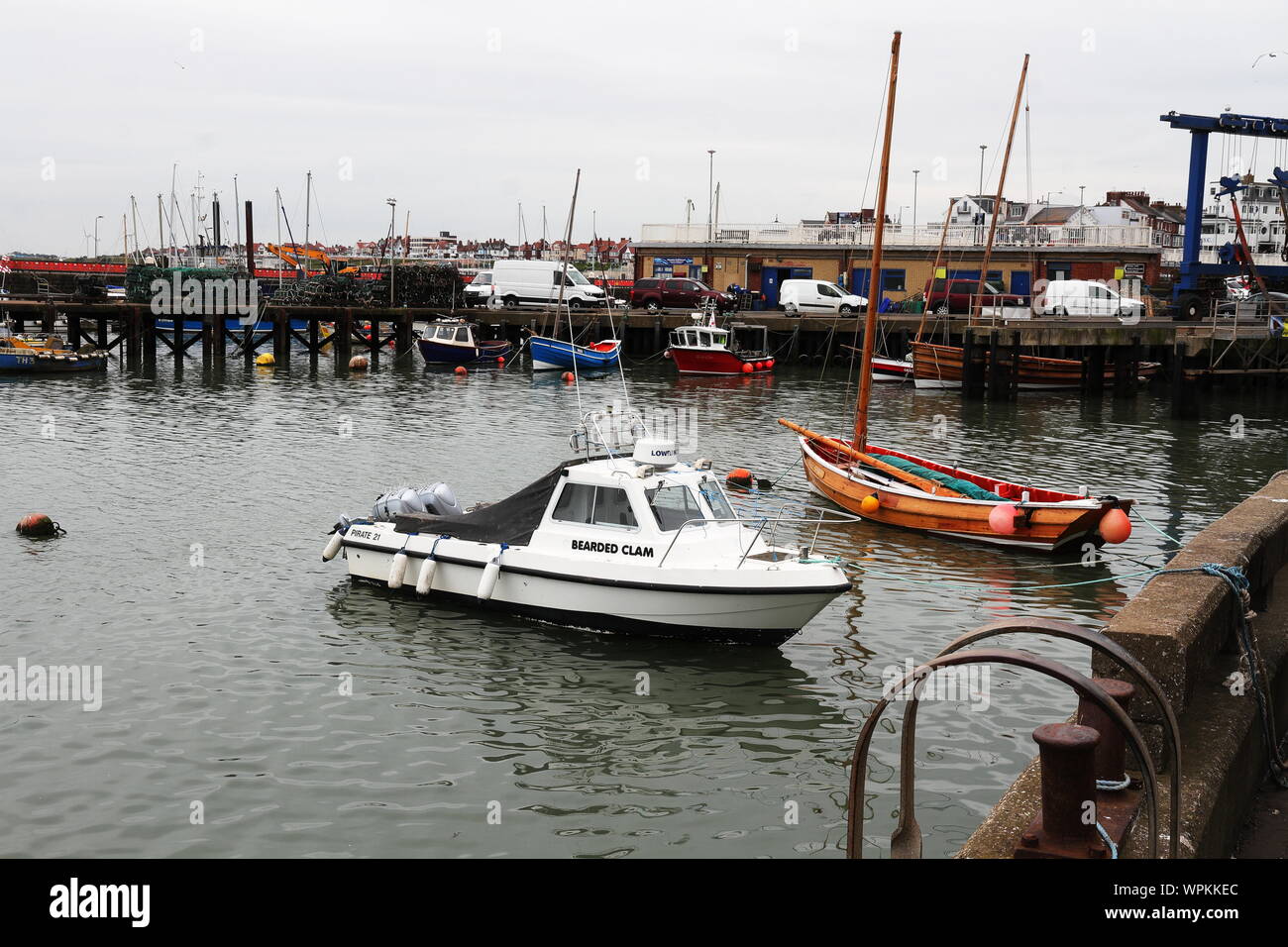 Boats in Bridlington harbour with reflections included.  One is a Yorkshire coble Stock Photo