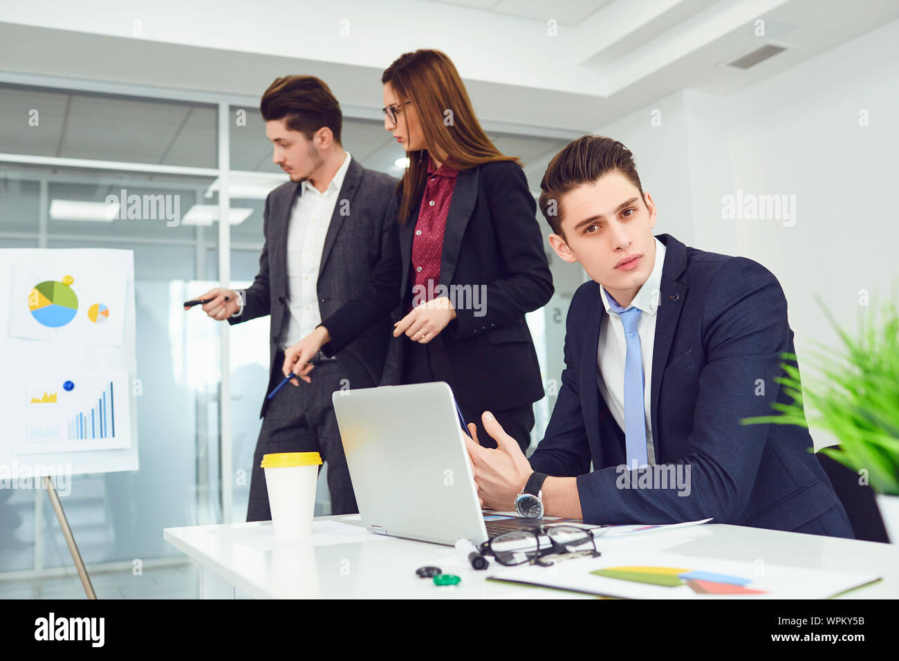 Serious young business people communicate at a table in an office. Stock Photo