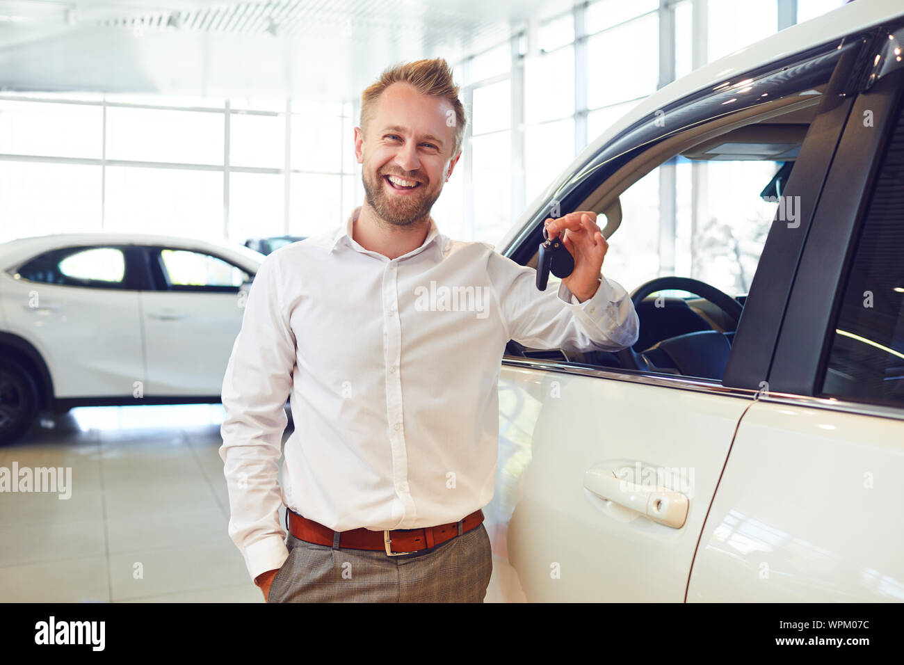 Happy buyer of a new car holds keys Stock Photo