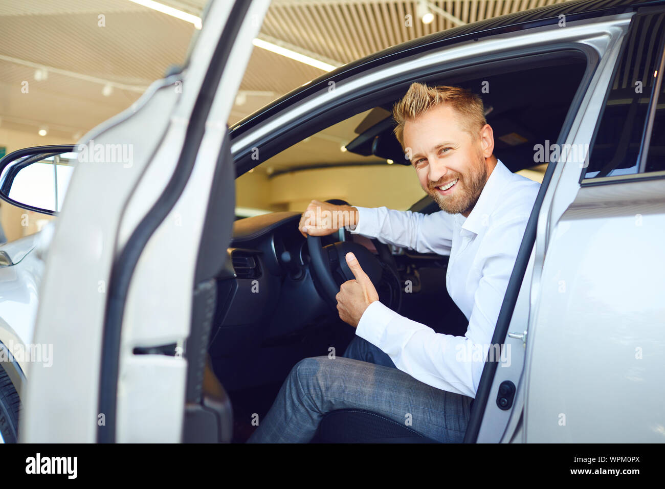A male buyer is sitting in a new car. Stock Photo