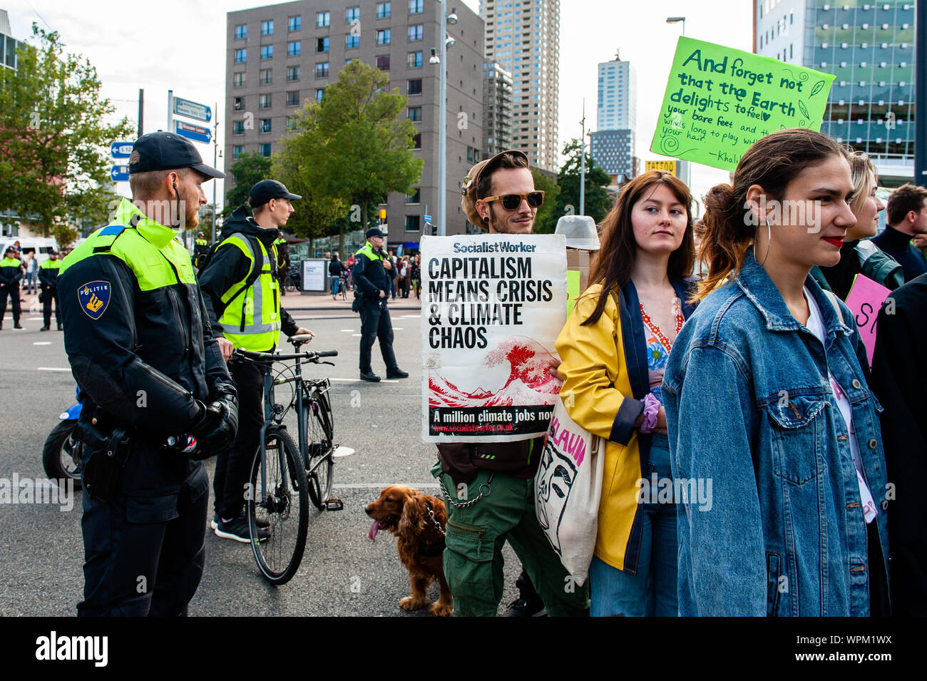 Protesters hold placards while marching on the street during the demonstration.During the famous world harbour days of Rotterdam, a Climate demonstration was organized by several organizations to demand that the harbour takes its responsibility for the climate crisis. According to the organizations involved in the march, the harbour of Rotterdam is responsible for 1/5th of the total CO2 emissions in the Netherlands. There was a strong police presence where the demonstration was passing by close to the Harbour Festival. Stock Photo