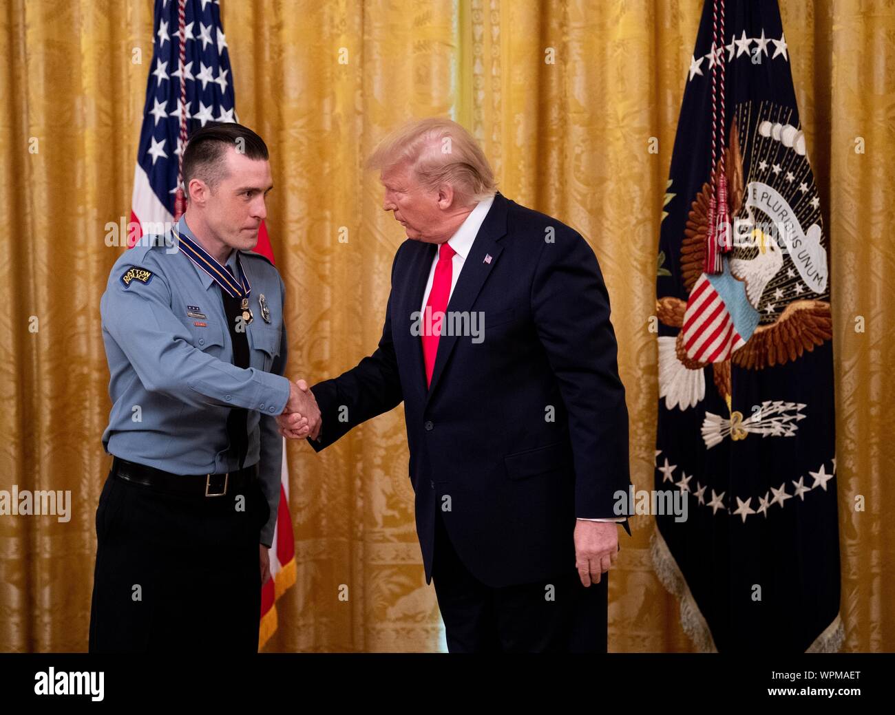 Washington, United States. 09th Sep, 2019. President Donald Trump awards Dayton Police Officer David Denlinger the Public Safety Officer Medal of Valor, during a ceremony in the East Room at the White House in Washington, DC on Monday, September 9, 2019. Trump recognized the six Dayton officers who stoped a mass shooting on August 4th and honored 5 civilians who helped during a mass shooting at a Walmart in El Paso a day before. Photo by Kevin Dietsch/UPI Credit: UPI/Alamy Live News Stock Photo