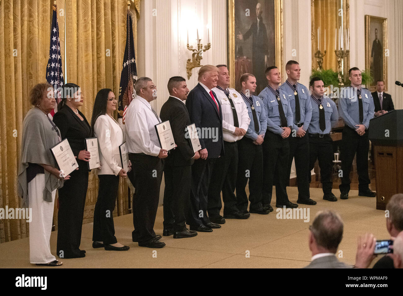 Washington, United States. 09th Sep, 2019. President Donald Trump smiles for a group photos during a ceremony in the East Room at the White House in Washington, DC on Monday, September 9, 2019. Trump gave Heroic Commendations awards to five El Paso citizens and six Dayton officers who help stop separate mass shootings with automatic weapons in El Paso and Dayton that claimed the lives of 31 people on consecutive days in August. Photo by Pat Benic/UPI. Credit: UPI/Alamy Live News Stock Photo