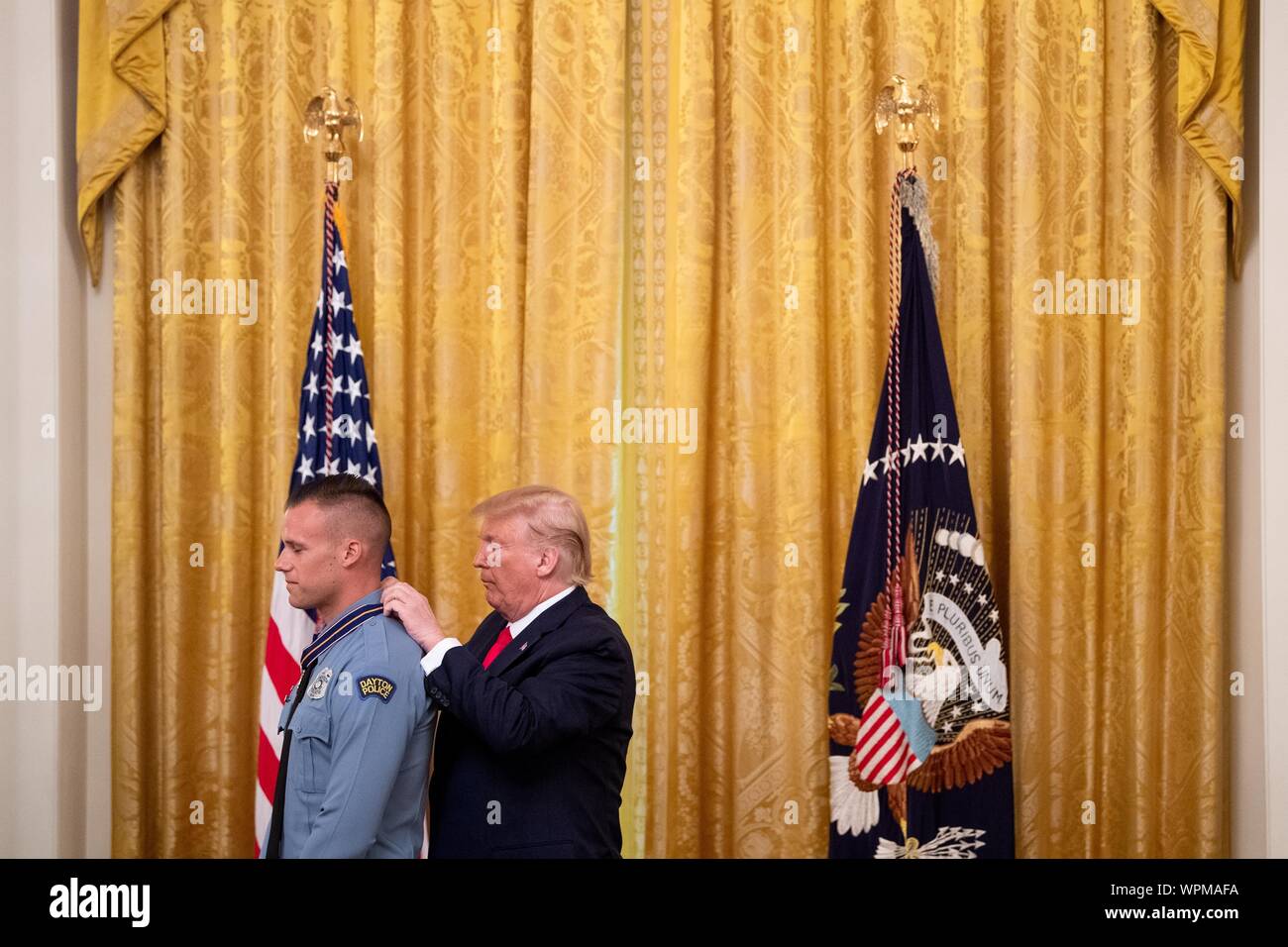 Washington, United States. 09th Sep, 2019. President Donald Trump awards Dayton Police Officer Vincent Carter the Public Safety Officer Medal of Valor, during a ceremony in the East Room at the White House in Washington, DC on Monday, September 9, 2019. Trump recognized the six Dayton officers who stoped a mass shooting on August 4th and honored 5 civilians who helped during a mass shooting at a Walmart in El Paso a day before. Photo by Kevin Dietsch/UPI Credit: UPI/Alamy Live News Stock Photo