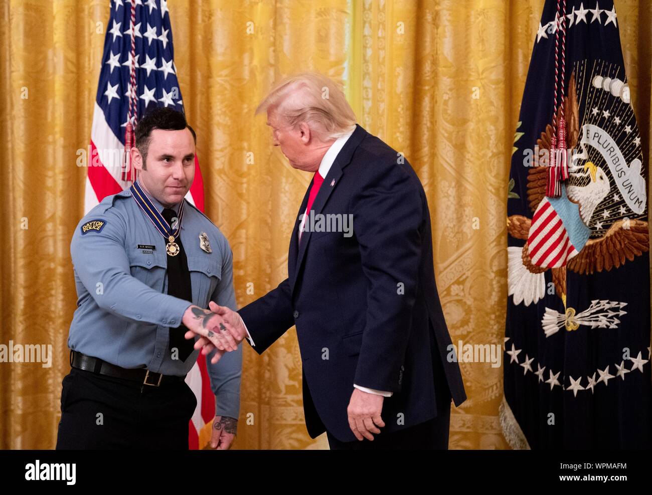 Washington, United States. 09th Sep, 2019. President Donald Trump awards Dayton Police Officer Ryan Nabel the Public Safety Officer Medal of Valor, during a ceremony in the East Room at the White House in Washington, DC on Monday, September 9, 2019. Trump recognized the six Dayton officers who stoped a mass shooting on August 4th and honored 5 civilians who helped during a mass shooting at a Walmart in El Paso a day before. Photo by Kevin Dietsch/UPI Credit: UPI/Alamy Live News Stock Photo