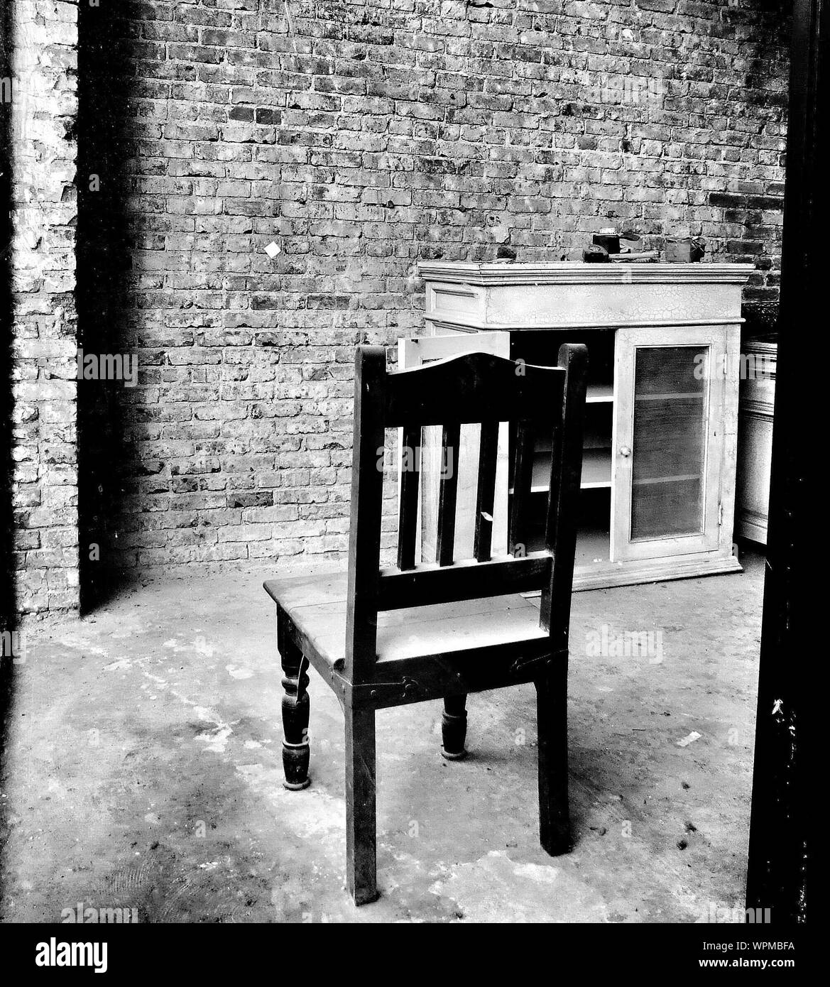 Empty Wooden Chair Against Brick Wall Stock Photo Alamy