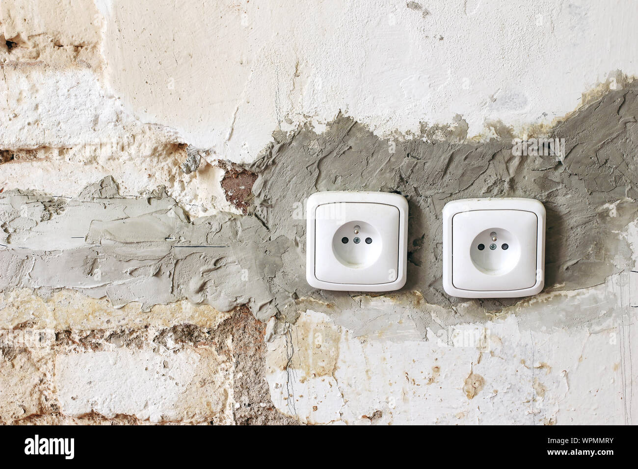 Couple of electric power plug sockets on old white dirty brick wall.  Electricity repair and reconstruction concept. Vintage grunge background,  home un Stock Photo - Alamy