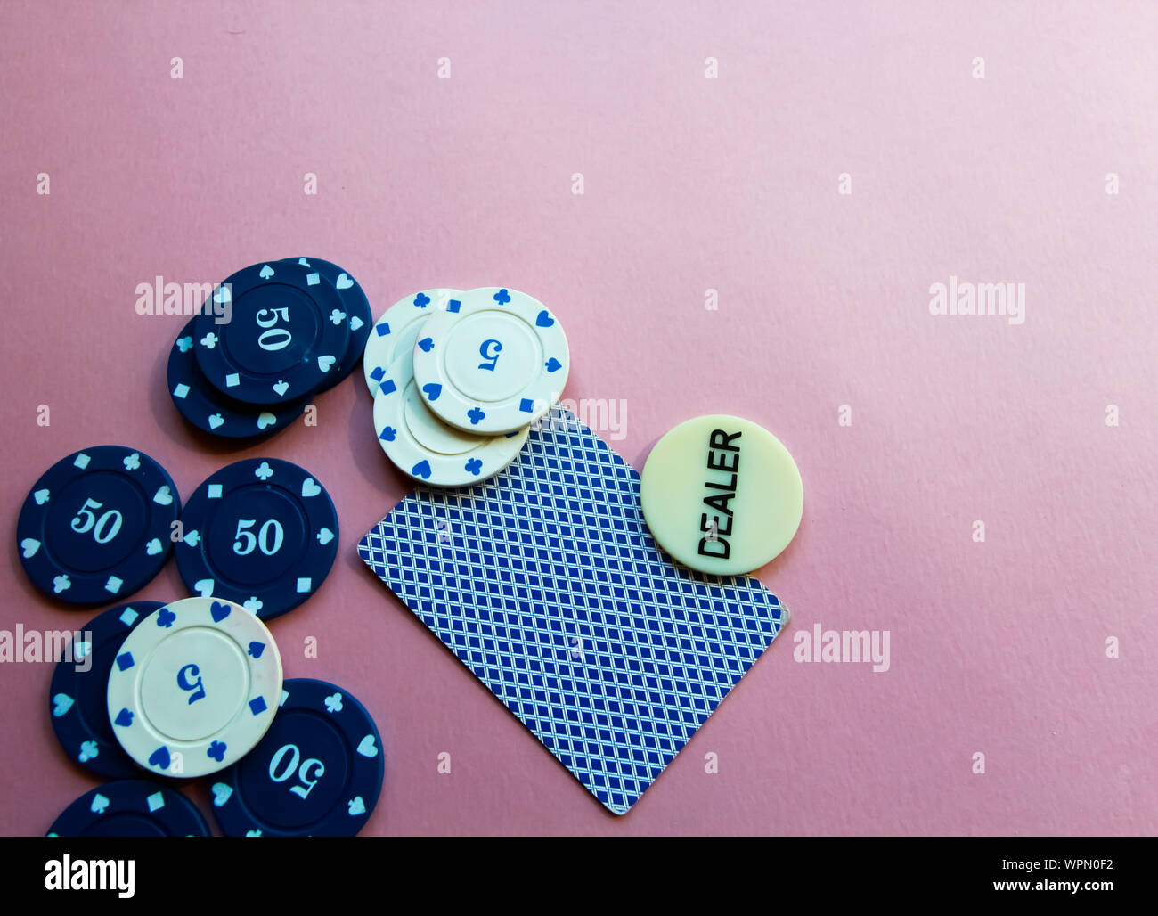 Chips and cards for poker on pink background. Poker play. Place for text. Stock Photo