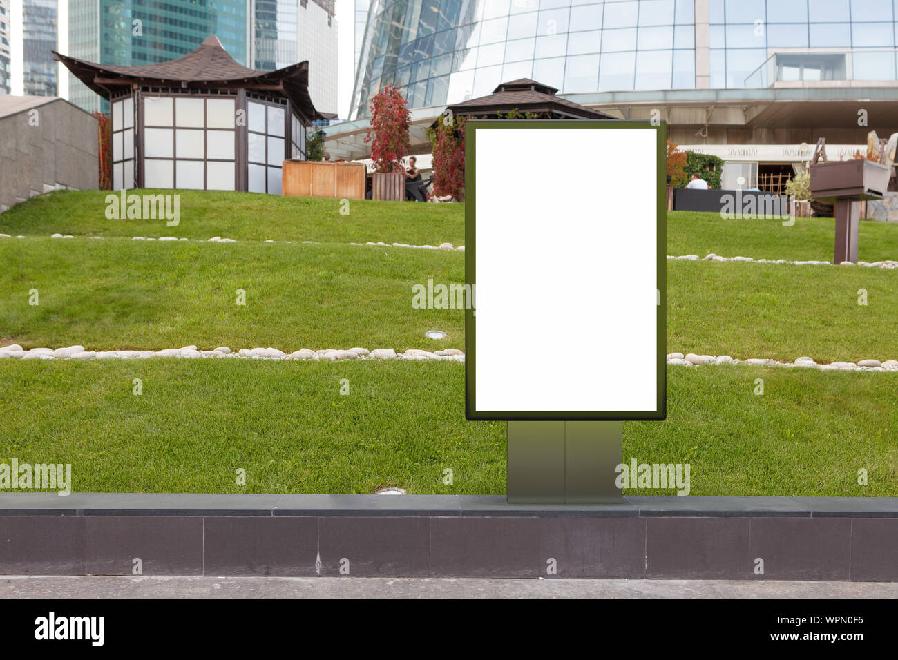 Blank street billboard poster stand mock up on the lawn in downtown ...