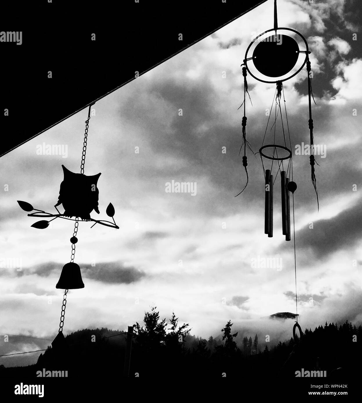 Low Angle View Of Dreamcatcher And Wind Chimes Hanging From Roof Stock Photo