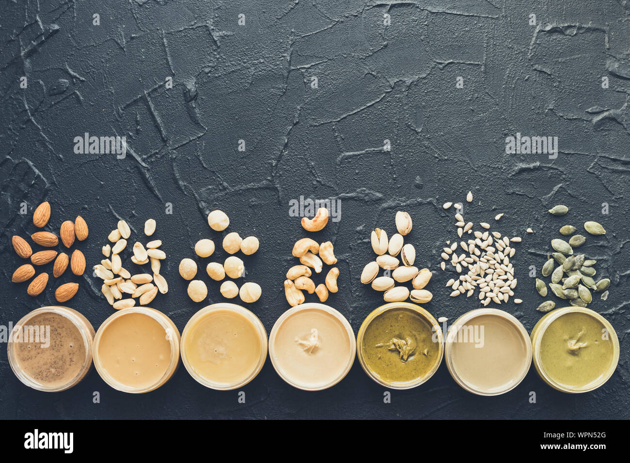 Nuts and seeds butter in jars with ingredients. Homemade raw organic