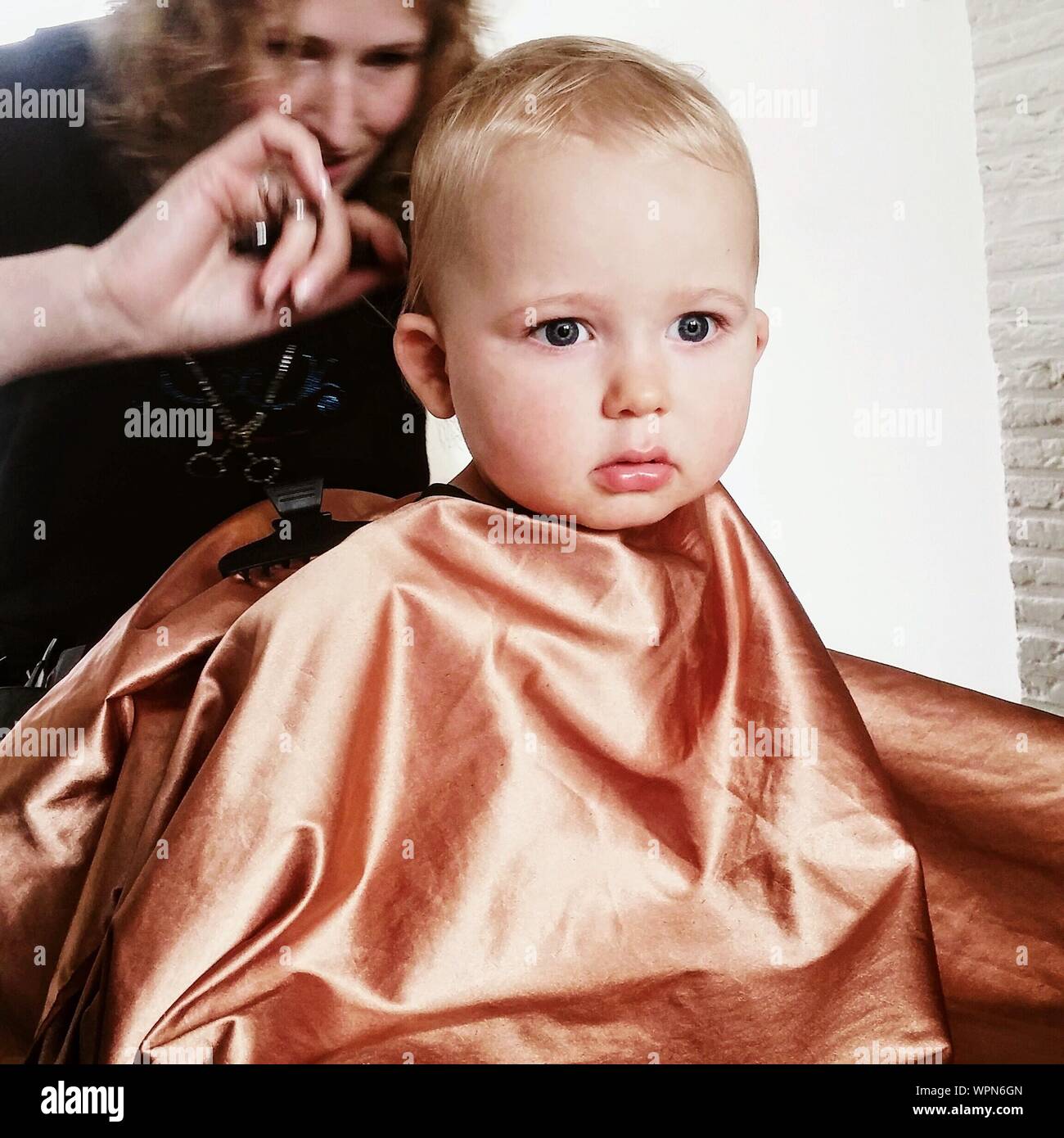 Female Hairdresser Cutting Baby Boy Hair At Hair Salon Stock Photo