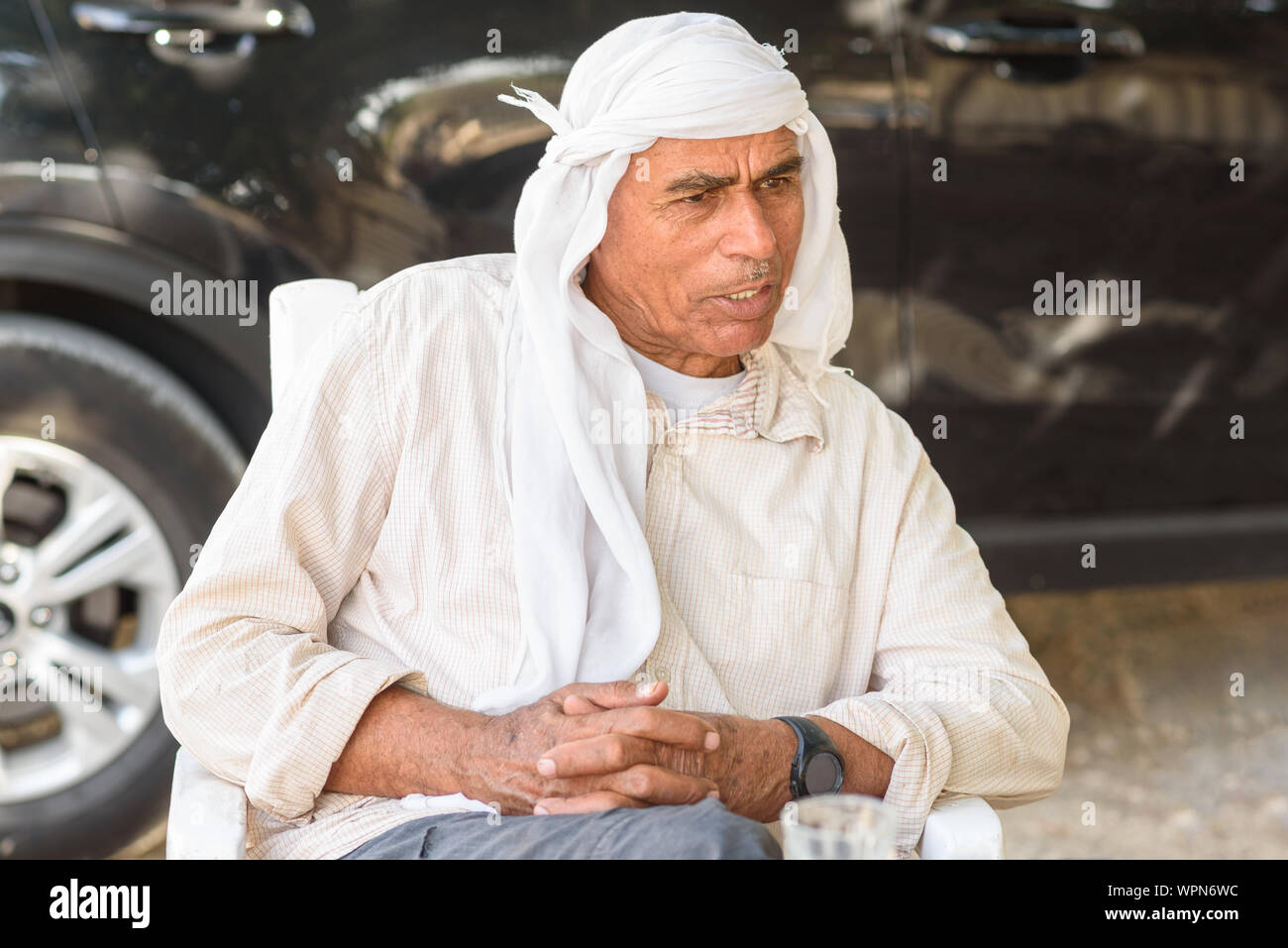 Old Arabic man in traditional clothes outdoor portrait. Serious Muslim Senior business man on a meeting. Stock Photo