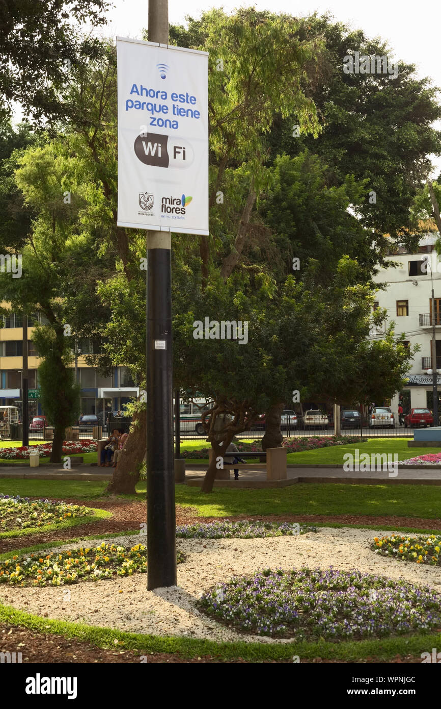 LIMA, PERU - DECEMBER 13, 2011: Wifi-Zone sign with unidentified people in the back in the Kennedy Park in the district of Miraflores in Lima, Peru Stock Photo
