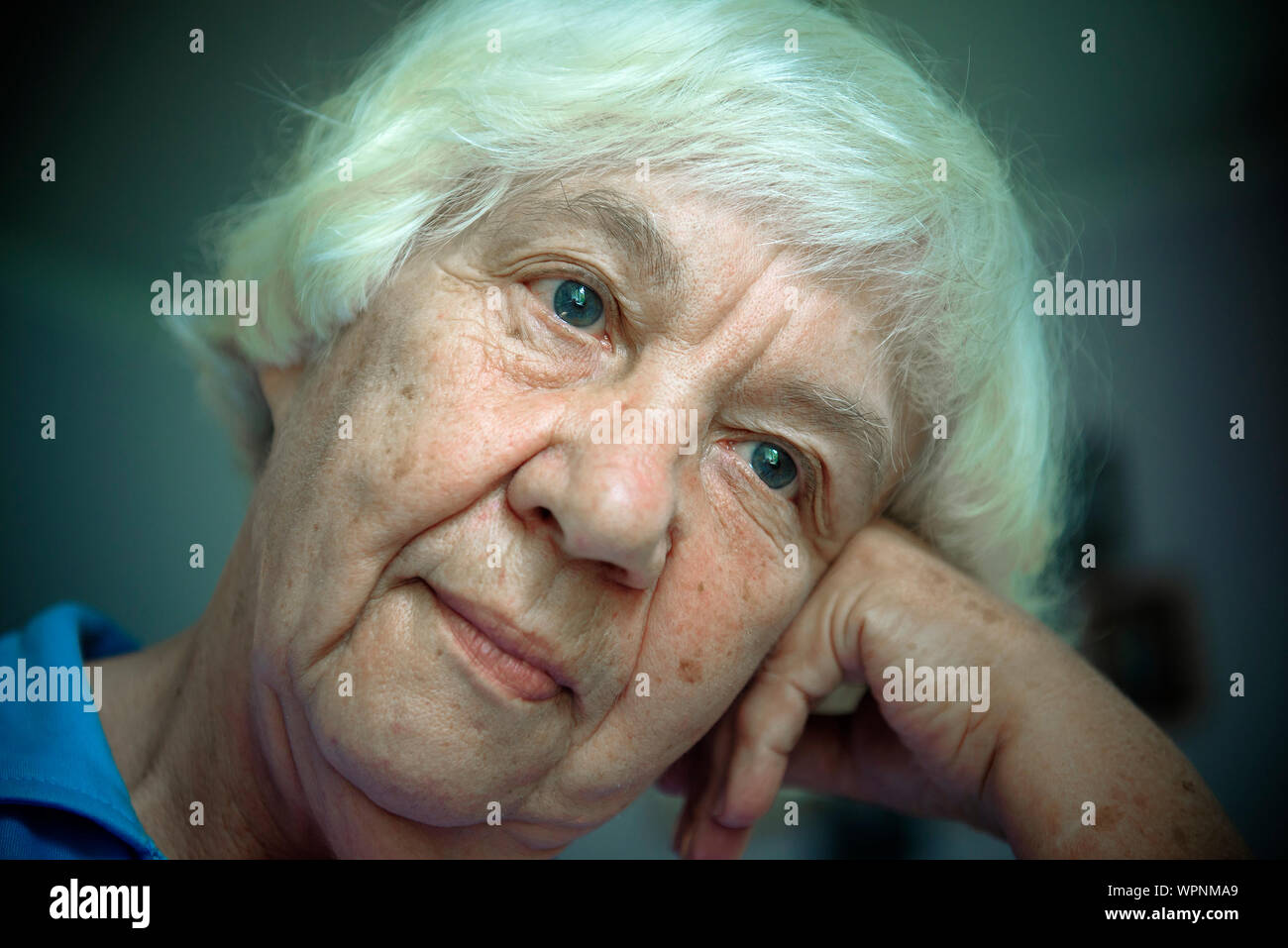 Close-up Of Thoughtful Senior Woman With Head Cocked Stock Photo