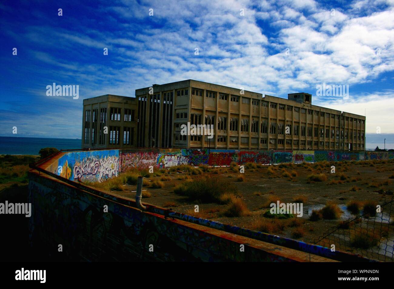 Old Power Station in Fremantle with graffiti on sunny day with blue sky and some clouds, next to the beach, lost places, Perth, Western Australia Stock Photo