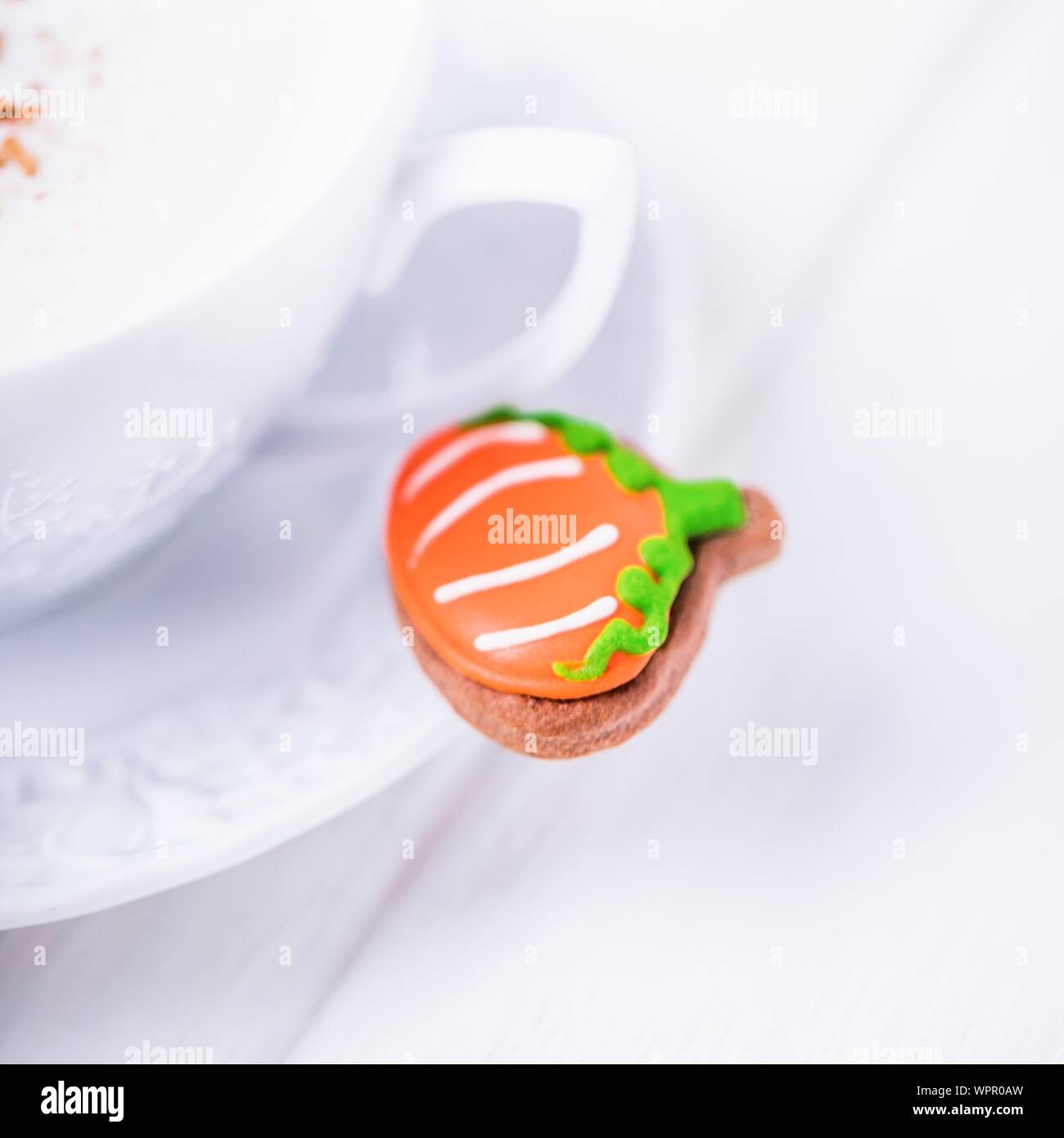 Gingerbread pumpkin and coffee cappuccino with cinnamon on white background. Copy space Stock Photo