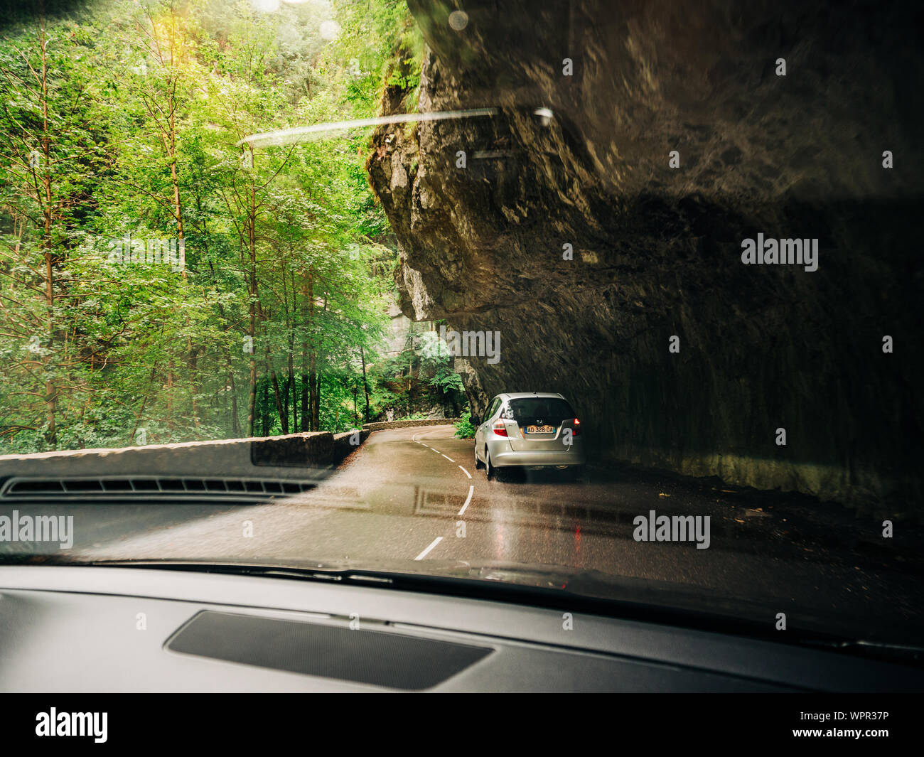 Chorance, France - Aug 11, 2017: POV from the car at the front driving Honda Jazz in Chorance in the Vercors Massif France under tall stones and fir trees Stock Photo