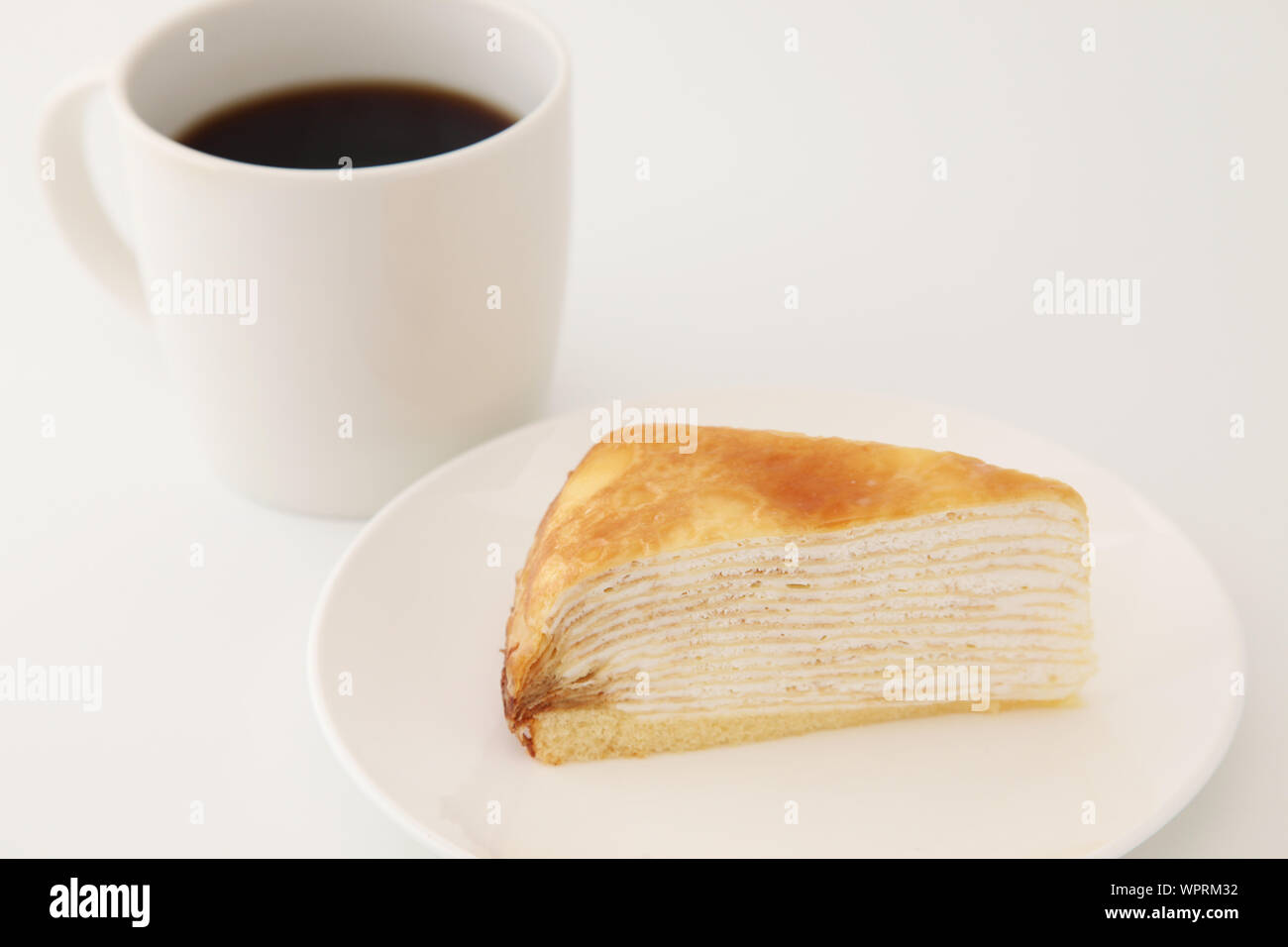 hot coffee with Mille crepe french cake on a plate isolated on white background Stock Photo