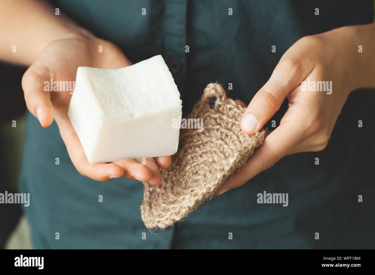 Eco-friendly cleaning kit. Organic soap and jute washcloth in the woman's hand. Zero waste concept, plastic-free, eco-friendly shopping, vegan Stock Photo