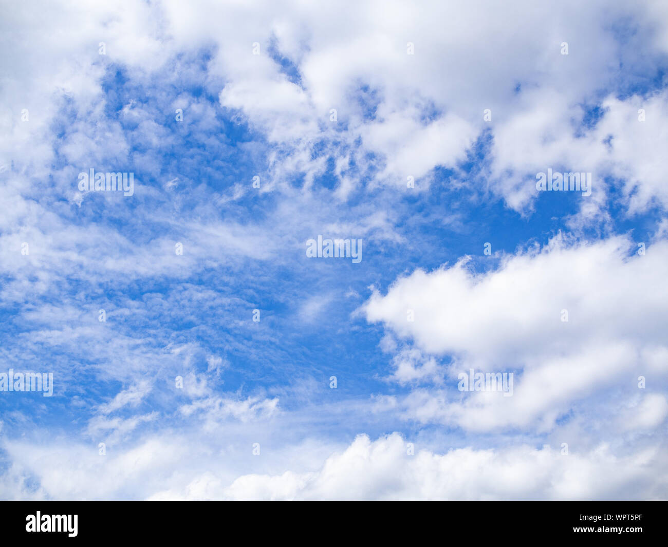 Blue skies shining through white clouds. Background. Stock Photo