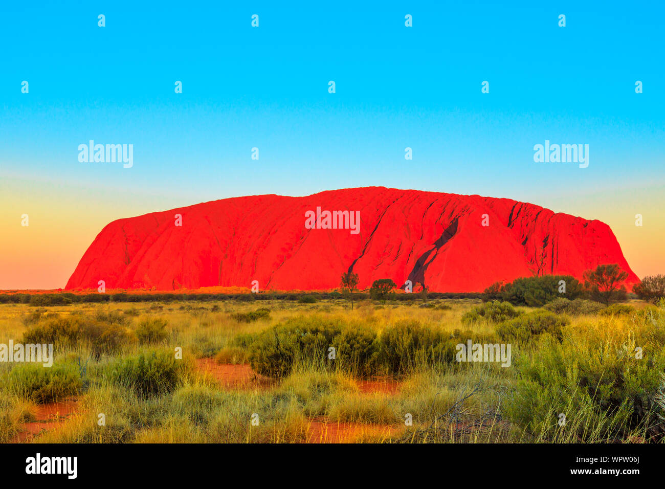 The red color of Uluru or Ayers Rock at sunset, the huge sandstone monolith in Uluru-Kata Tjuta National Park, icon of Australian outback or Red Stock Photo